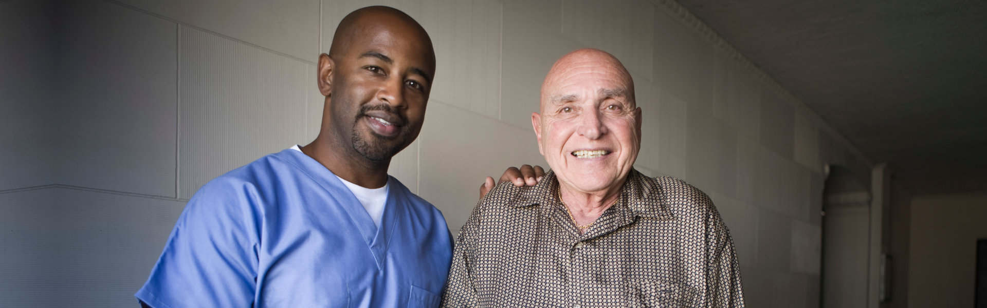 nurse and elderly man looking at the camera